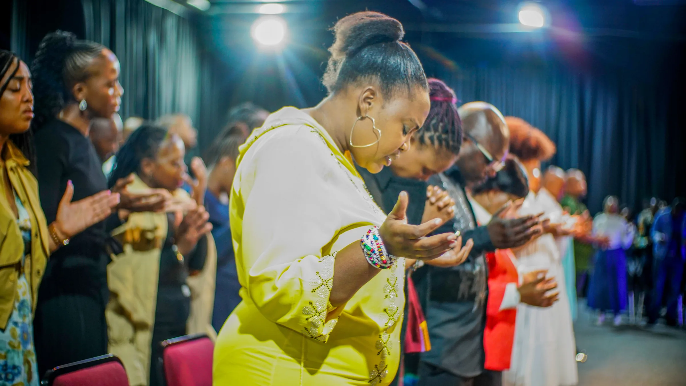 Women of Mirror Christ Church standing together in prayer